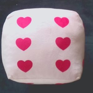 Pink comfy pillow in the shape of a dice. All darker pink hearts on all sides!